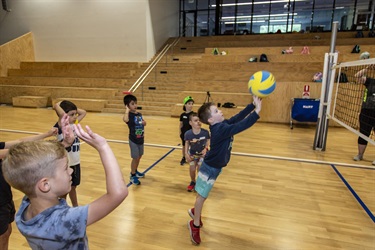 Team of kids hit volleyball back over the net