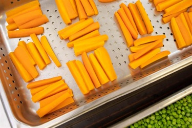 Carrot sticks in a tray, ready to be roasted