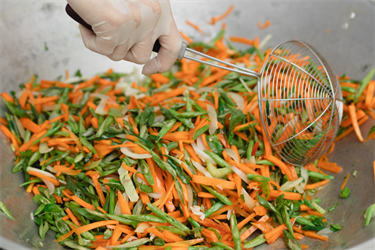 fresh vegetables being stir-fryed in a wok