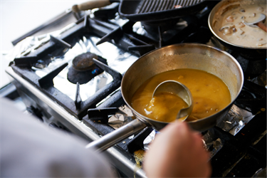 Pans on the stovetop with a variety of sauces being prepared