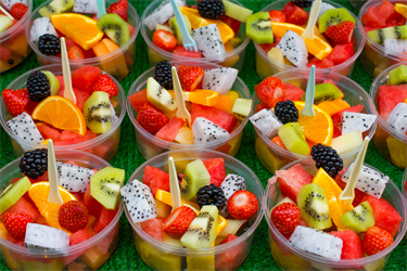 many servings of fruit salad sitting next to each other, waiting to be delivered to seniors