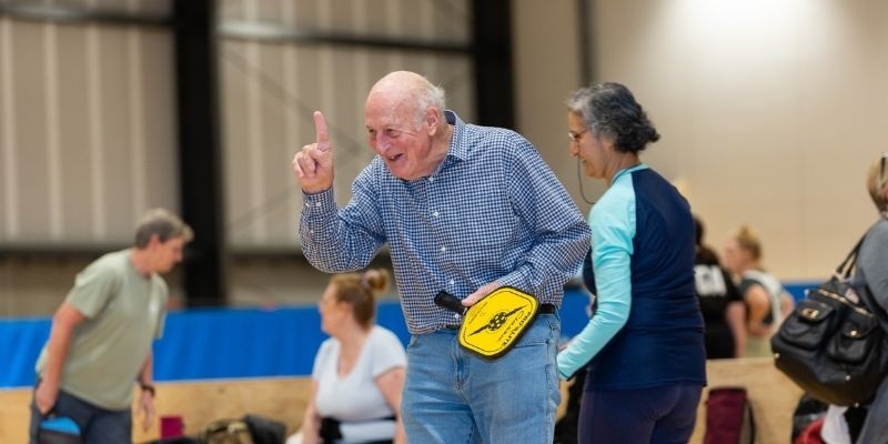 senior person playing pickleball