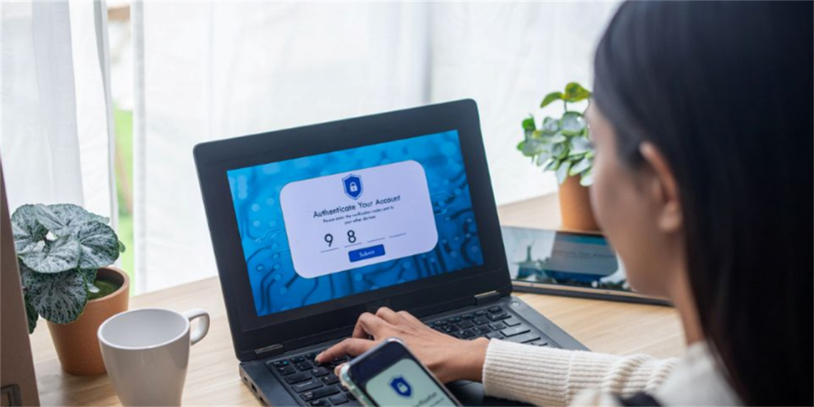 Person sitting at a desk looking at an open laptop