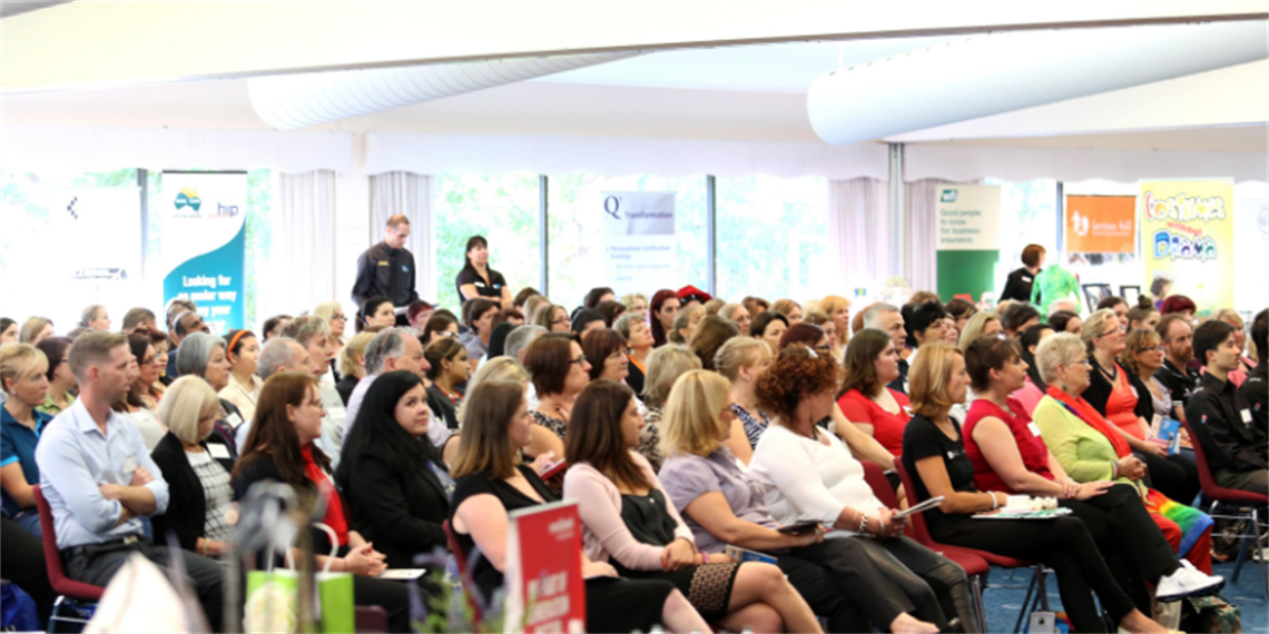 Rows of seated people looking towards a guest speaker