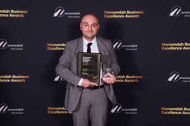 Sustainnovate 2026 award recipient with trophy and certificate.