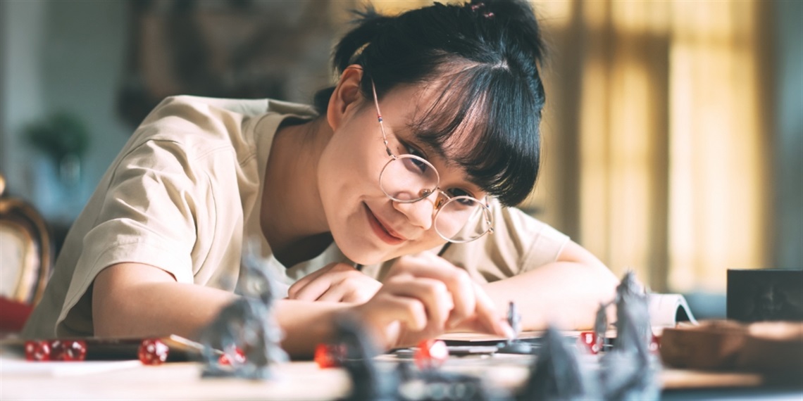 Young person moving a piece on a tabletop game