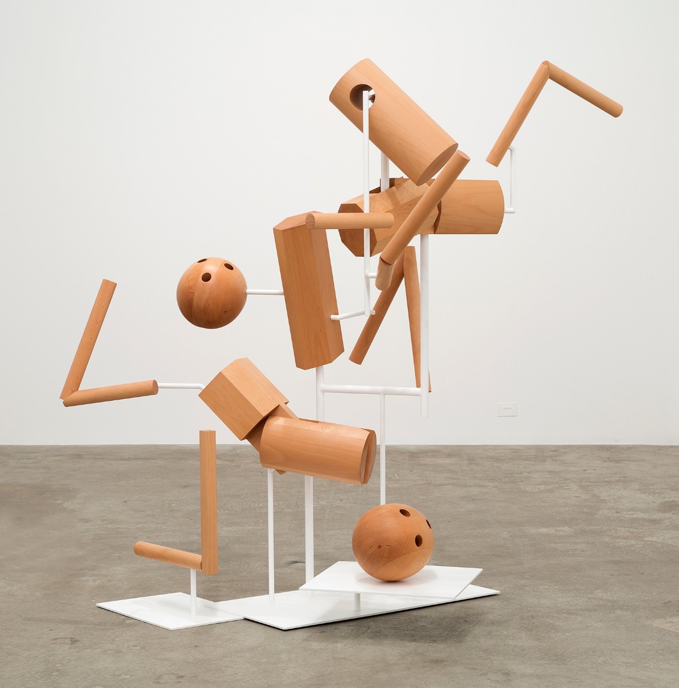 Abstract timber sculpture featuring suspended geometric shapes on a white frame.