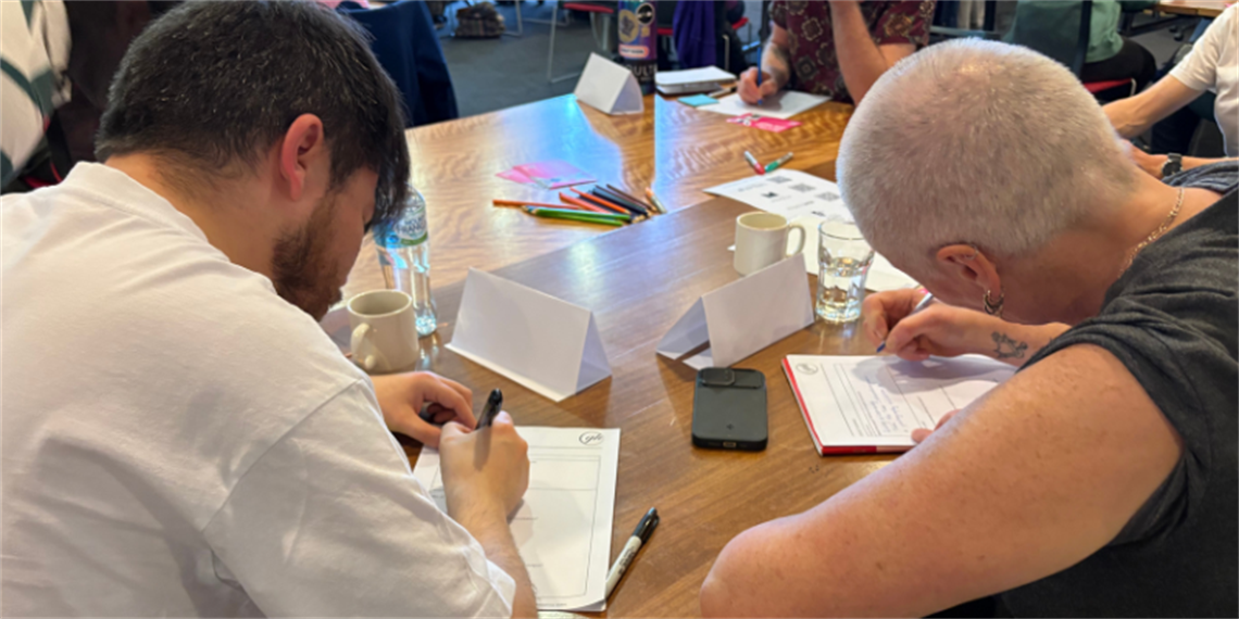 People seated around a table completing worksheets during a group activity.