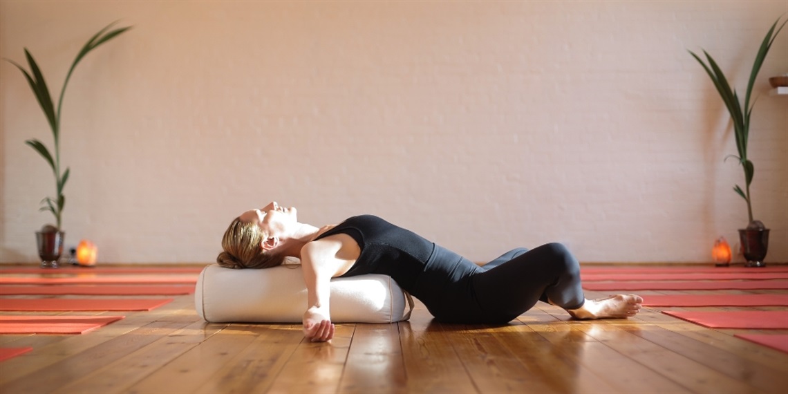 Person stretching back on yoga pillow