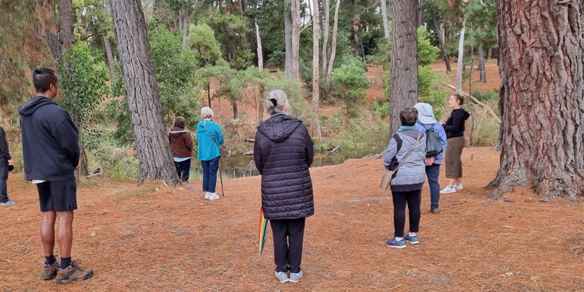 Group of people walking across a bridge along a trail