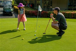 man and girl playing golf