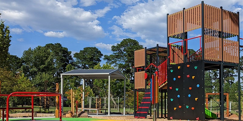 McAlpin playground A colourful playground with red stairs, a rock climbing wall and a green slide