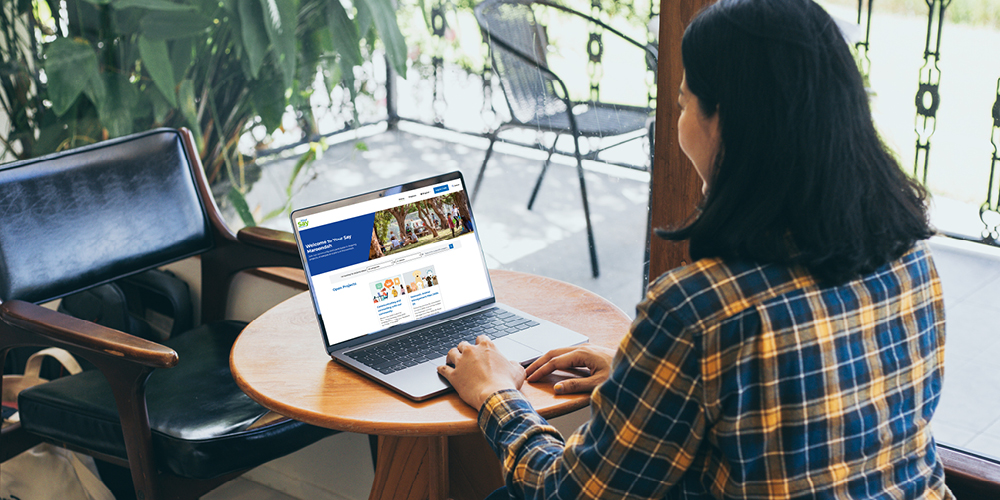 Person sitting at a table, looking at the new Your Say Maroondah website on their laptop