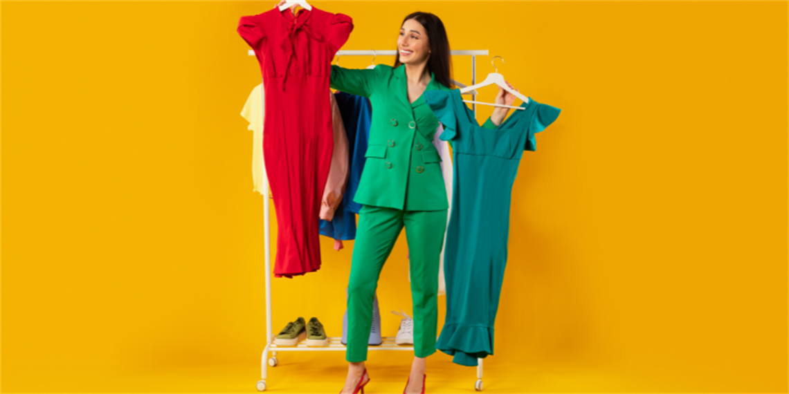 Woman holding up two dresses.png