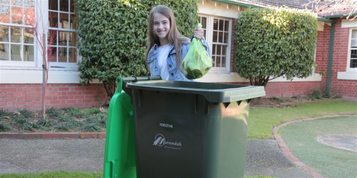 Young person placing food waste into their FOGO bin