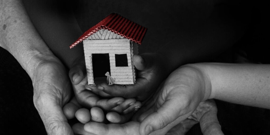 Hands holding a yellow house