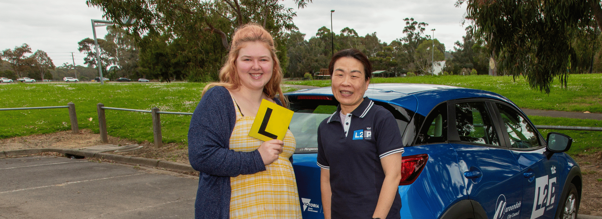 Maroondah L2P participant and mentor standing beside blue car.png