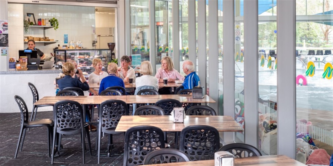 A group of people sitting at a table in the K Cafe at Aquahub